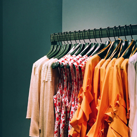 a rack of color clothes against blue background