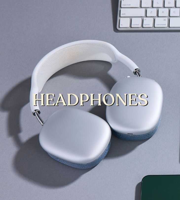 Headphones: silver over-ear headphones on a gray desk beside a keyboard.