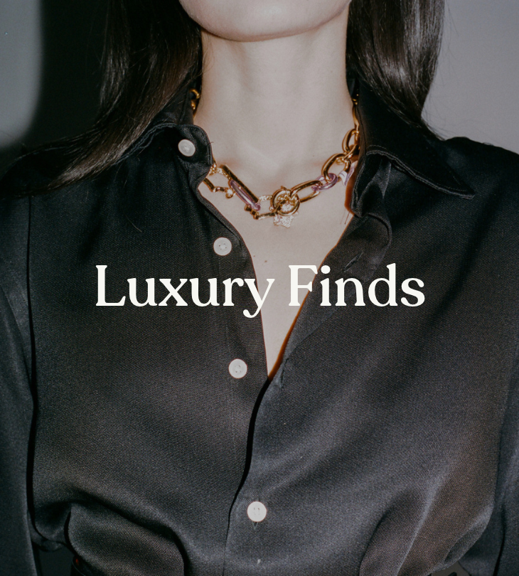 Luxury Finds: model wearing a chunky gold-tone chain necklace and black button-up shirt.