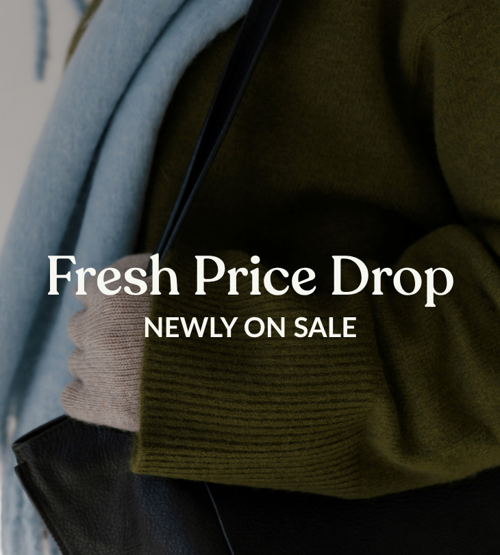 Fresh Price Drop, newly on sale, over a close-up of layered clothing with an olive-green knit sleeve and light-blue fabric