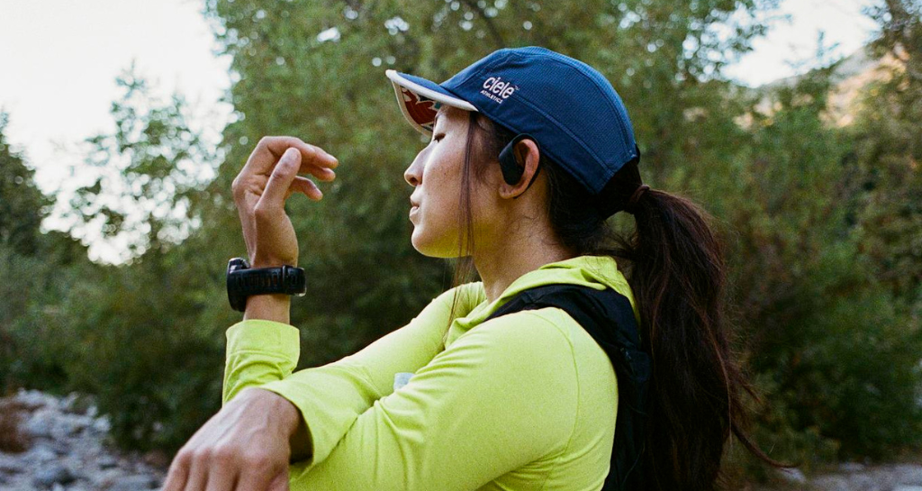 a woman in wireless headphones in the woods