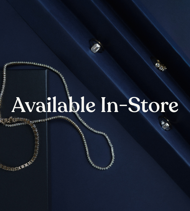 Sparkling jewelry displayed on dark blue velvet with the text ‘Available In-Store.