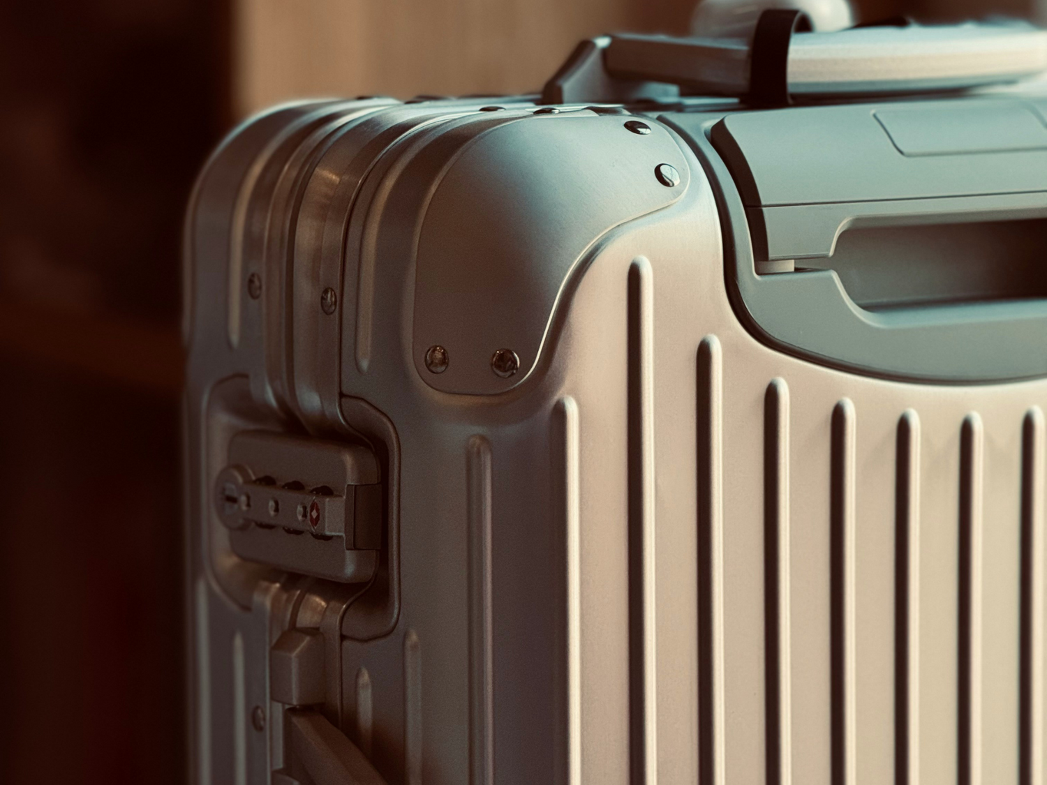 Close-up of a silver metal suitcase with a blurred background