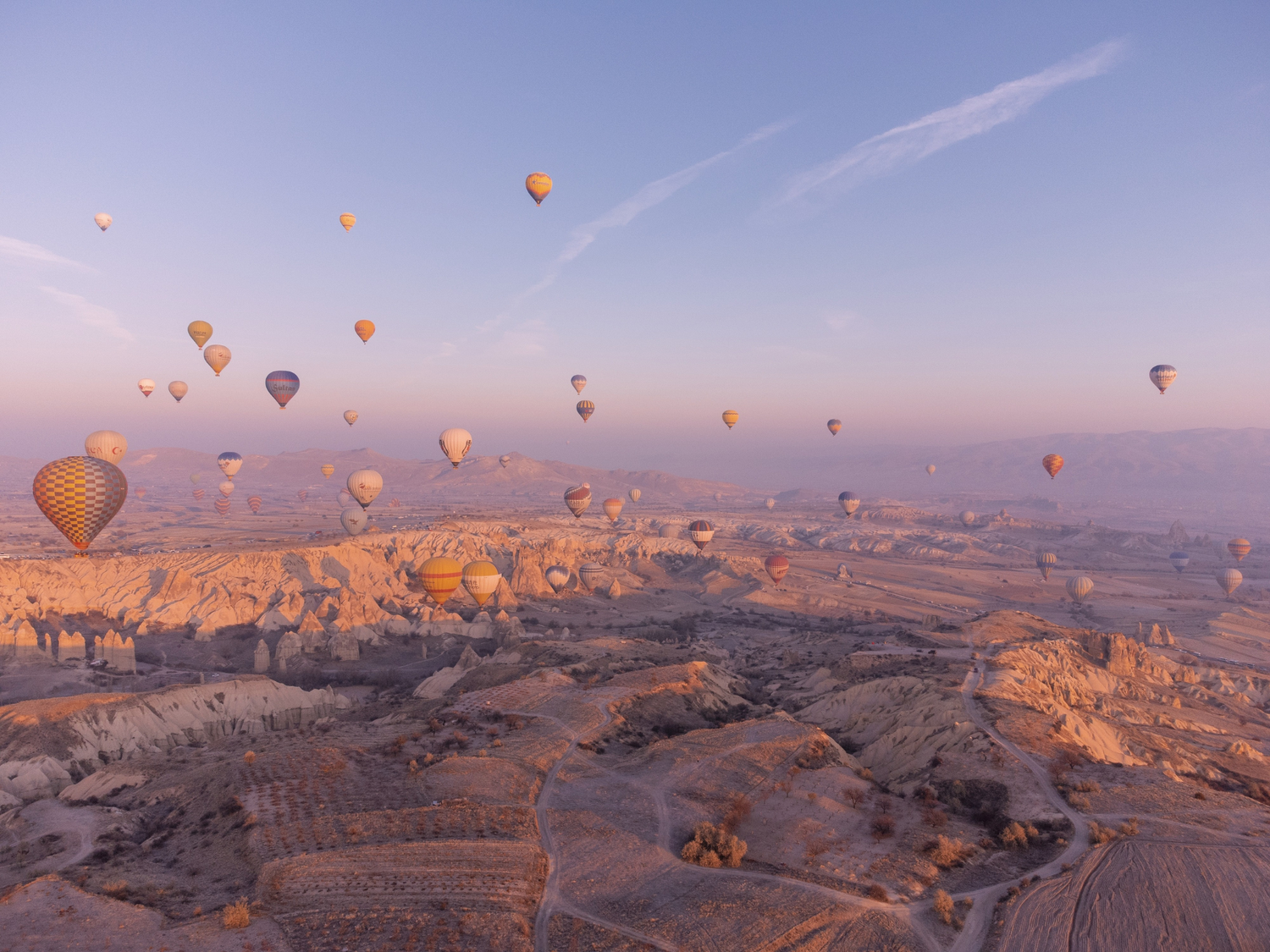 Hot air balloons floating over a landscape with a clear sky