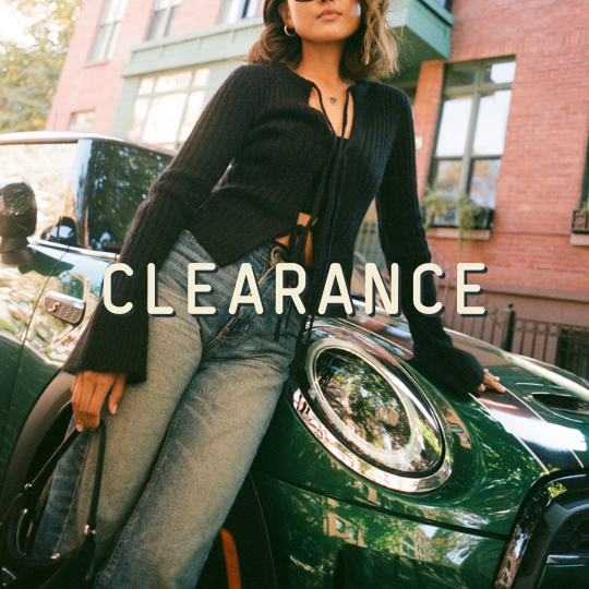 Woman sitting on a green car with 'CLEARANCE' text overlay