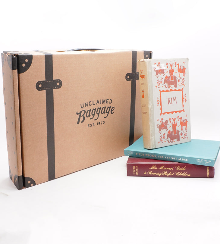 a unclaimed baggage kraft box with books