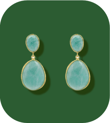 Pair of earrings with green stones on a green background