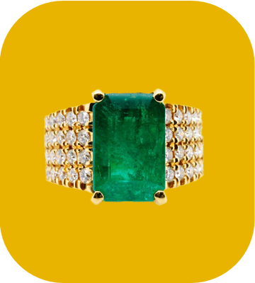 Gold ring with a green gemstone and diamond accents on a yellow background